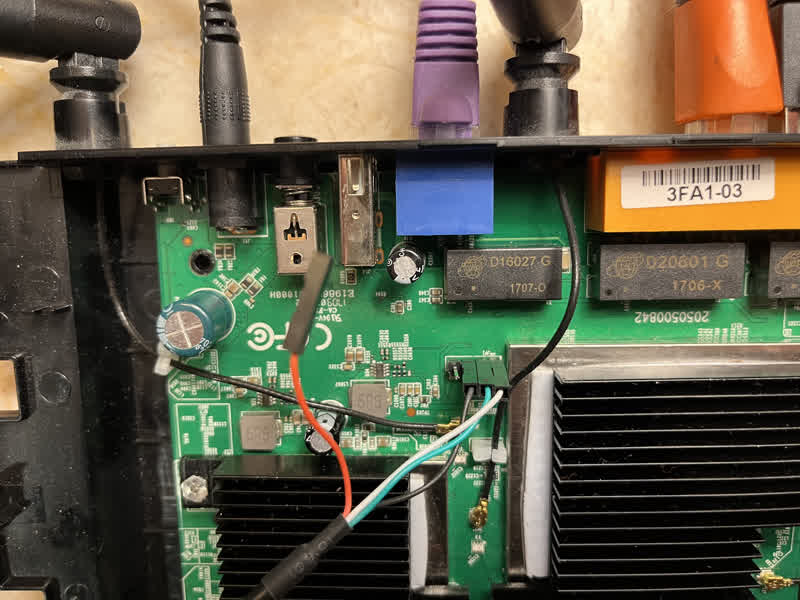 Photo of the top of a TP-Link Archer C59 AC1350 circuit board with three out of the four UART wires connected to three out of the four available soldered serial port headers