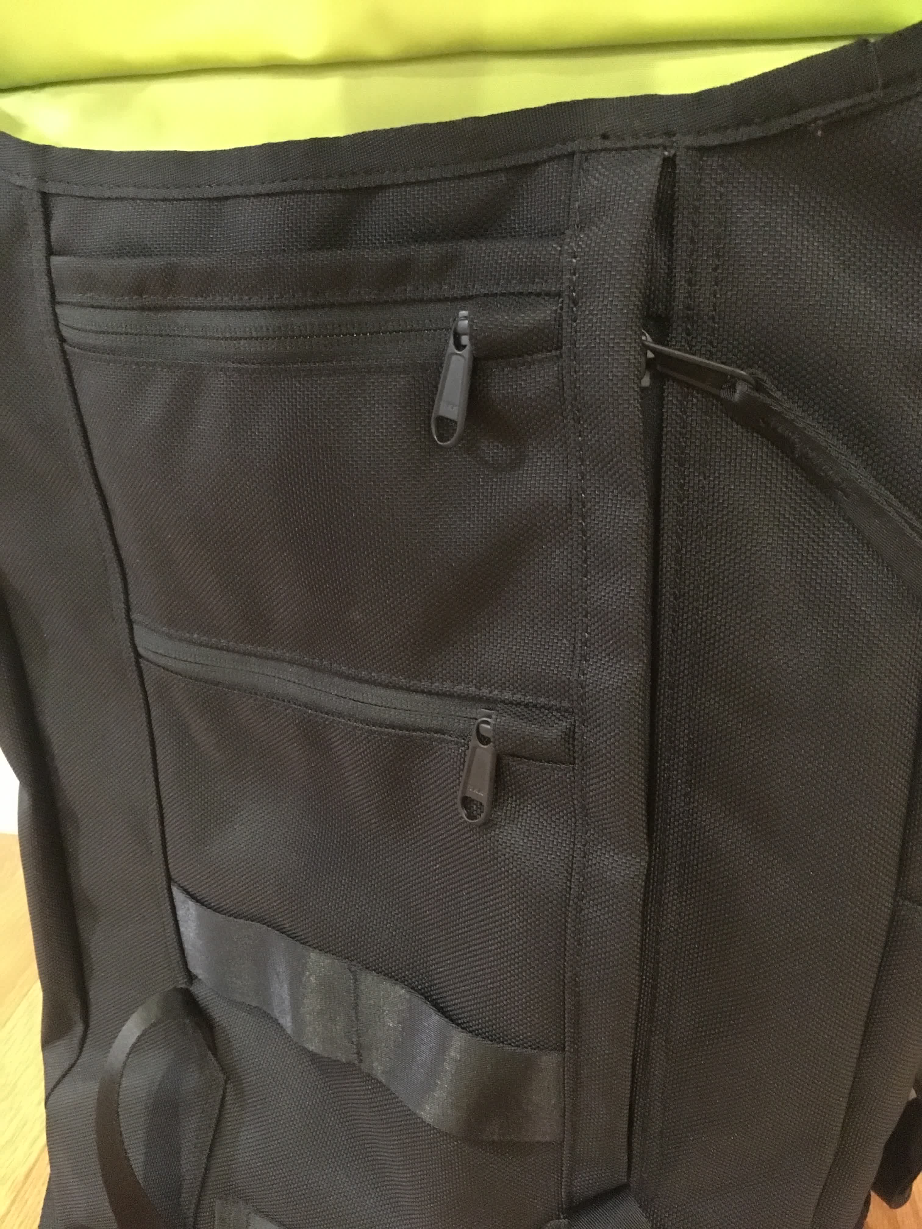 Several pockets line the front of the bag